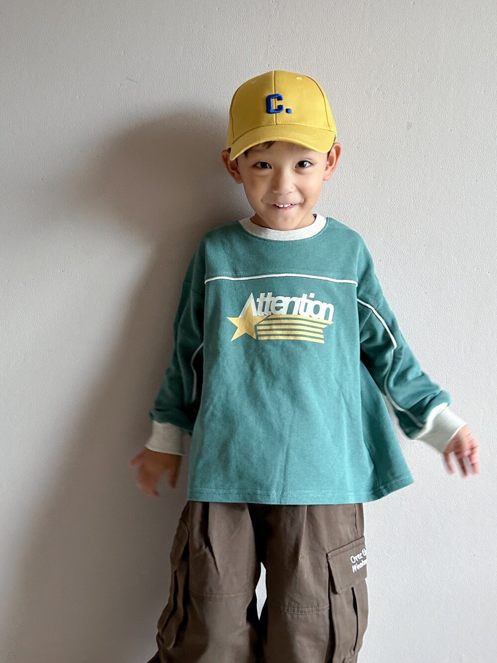 グリーン系のスウェット、ベージュ系のカーゴパンツ、ホワイト系のスニーカーを着用したキッズの秋コーディネートの5枚目の写真