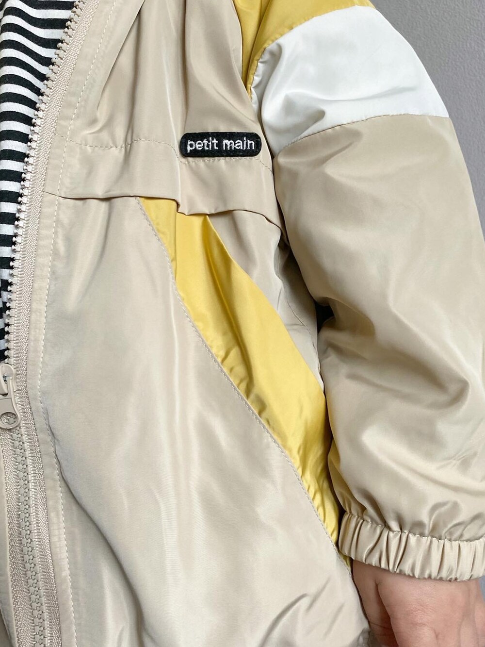 ブラック系のTシャツ/カットソー、ベージュ系のブルゾン、ホワイト系のスニーカーを着用したキッズの春コーディネートの4枚目の写真