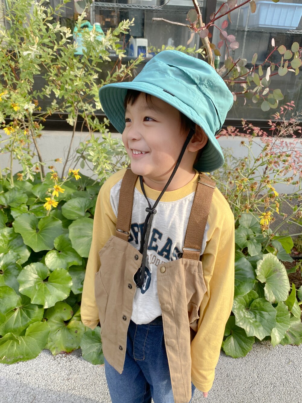 イエロー系のTシャツ/カットソー、ブルー系のデニムパンツ、ブラック系のスニーカーを着用したキッズの冬コーディネートの2枚目の写真