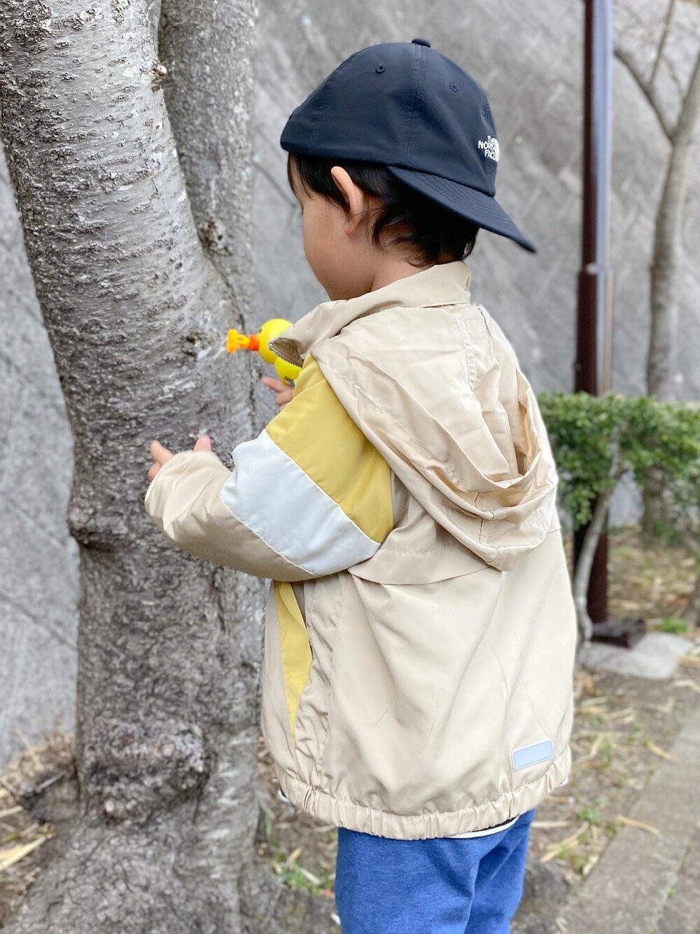 ブラック系のTシャツ/カットソー、ベージュ系のブルゾン、ホワイト系のスニーカーを着用したキッズの春コーディネートの3枚目の写真