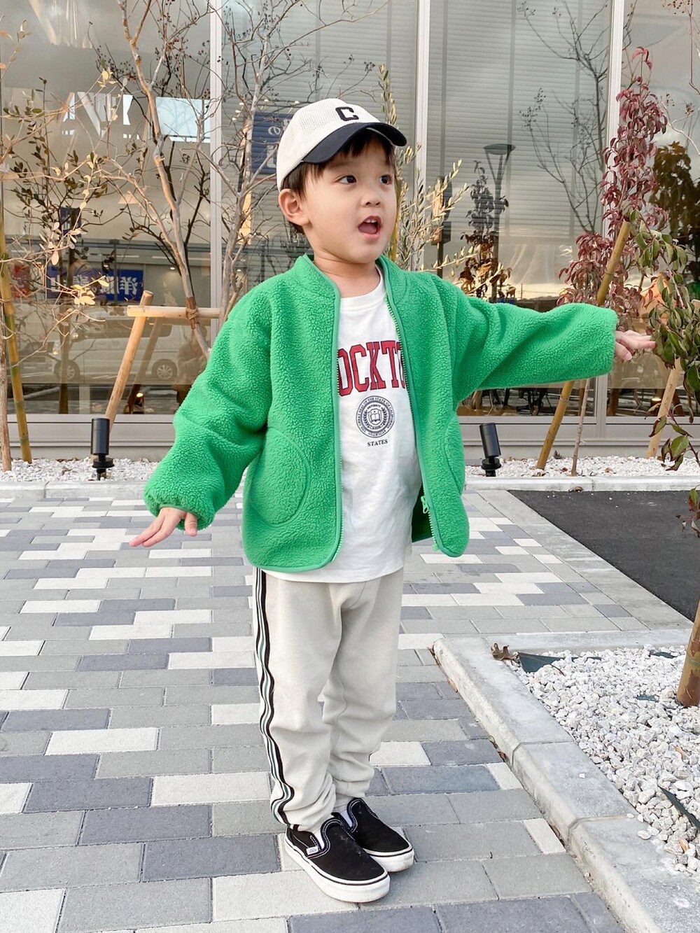 グリーン系のブルゾン、ホワイト系のTシャツ/カットソー、ベージュ系のその他パンツを着用したキッズの春コーディネートの4枚目の写真