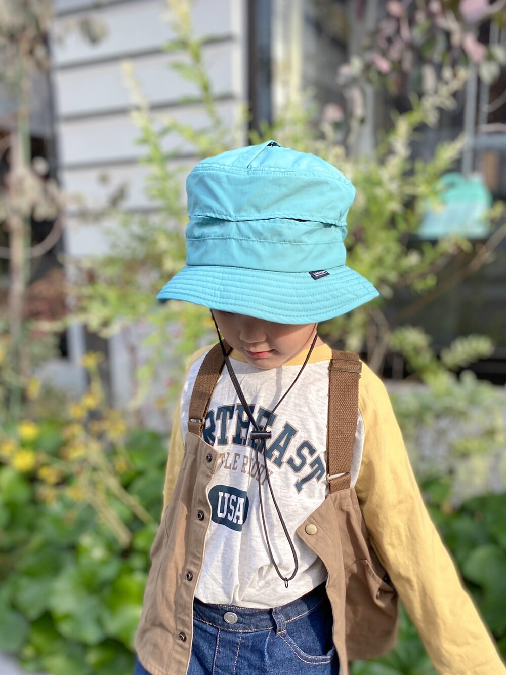 イエロー系のTシャツ/カットソー、ブルー系のデニムパンツ、ブラック系のスニーカーを着用したキッズの冬コーディネートの3枚目の写真