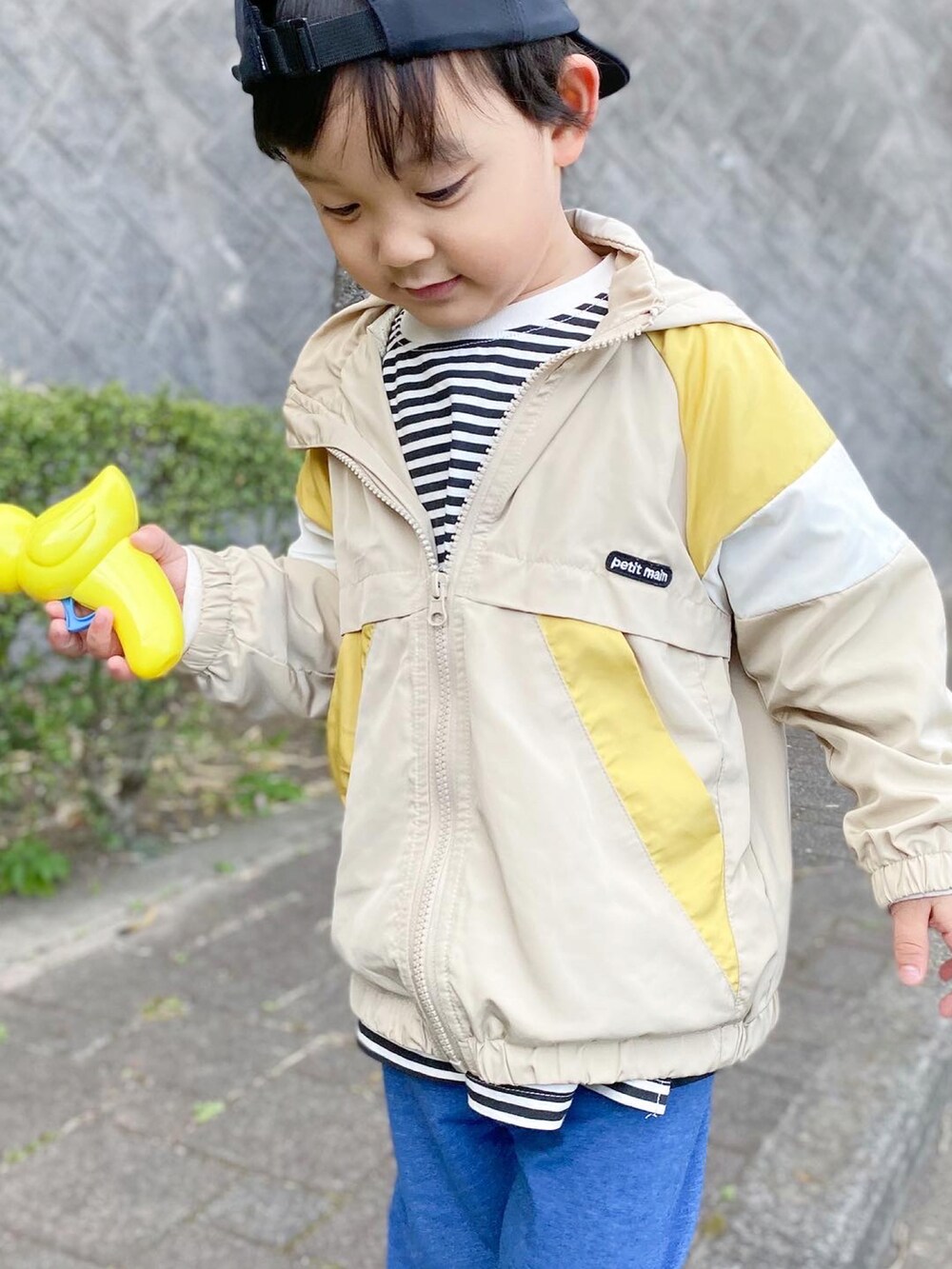 ブラック系のTシャツ/カットソー、ベージュ系のブルゾン、ホワイト系のスニーカーを着用したキッズの春コーディネートの2枚目の写真