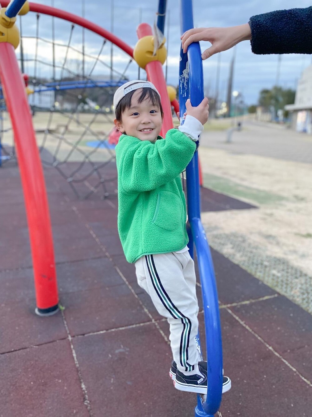 グリーン系のブルゾン、ホワイト系のTシャツ/カットソー、ベージュ系のその他パンツを着用したキッズの春コーディネートの3枚目の写真