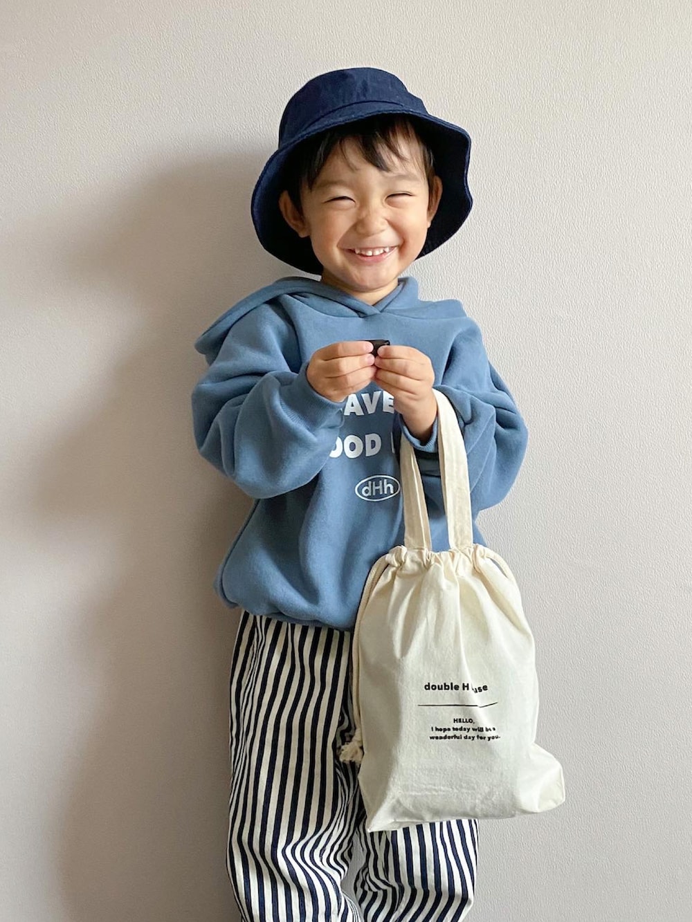 ブルー系のパーカー、ホワイト系のバッグ、その他のデニムパンツを着用したキッズの冬コーディネートの5枚目の写真