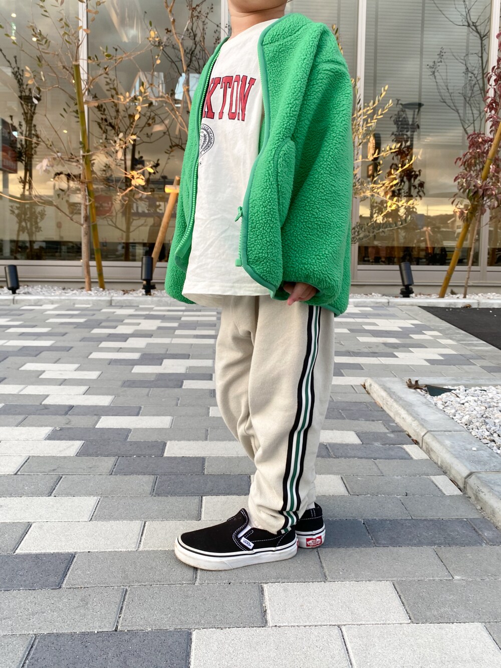 グリーン系のブルゾン、ホワイト系のTシャツ/カットソー、ベージュ系のその他パンツを着用したキッズの春コーディネートの2枚目の写真