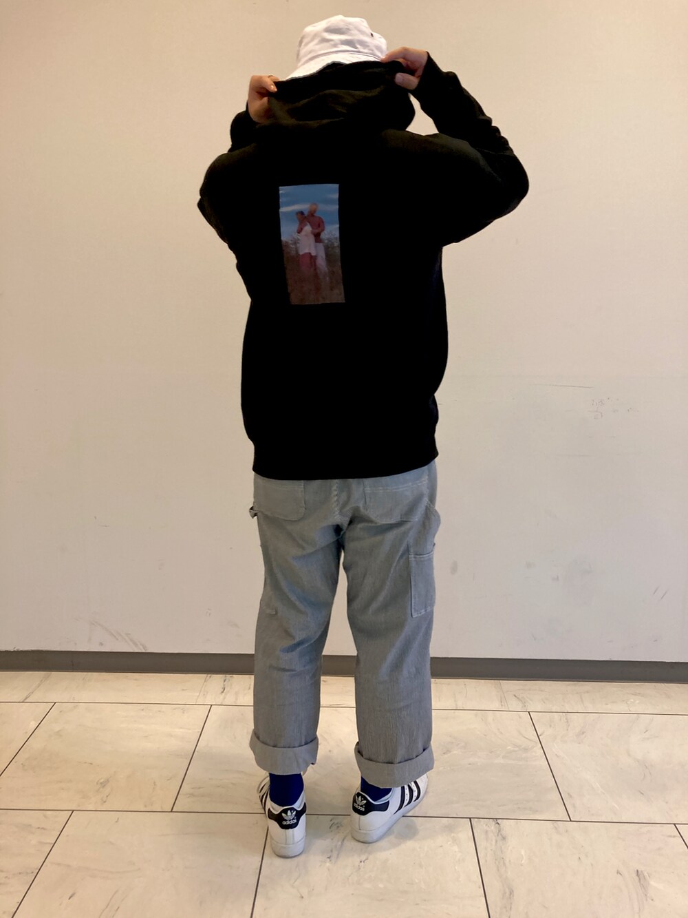 ホワイト系のその他パンツ、ホワイト系のスニーカー、ブラック系のパーカーを着用したメンズの秋コーディネートの2枚目の写真