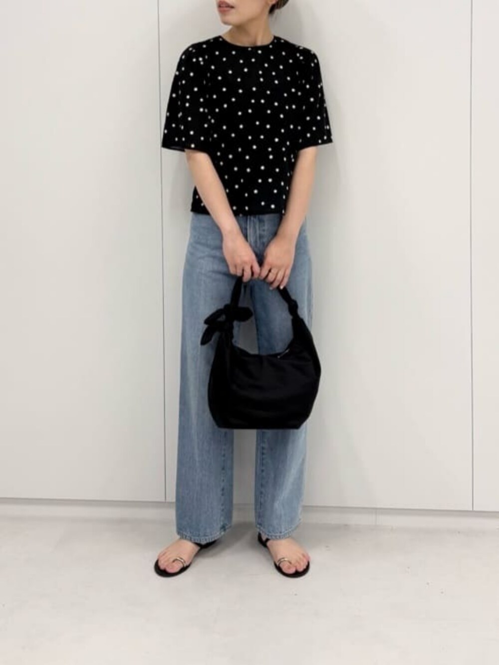 ブルー系のデニムパンツ、ブラック系のショルダーバッグ、ブラック系のシャツ/ブラウスを着用したレディースの夏コーディネートの4枚目の写真