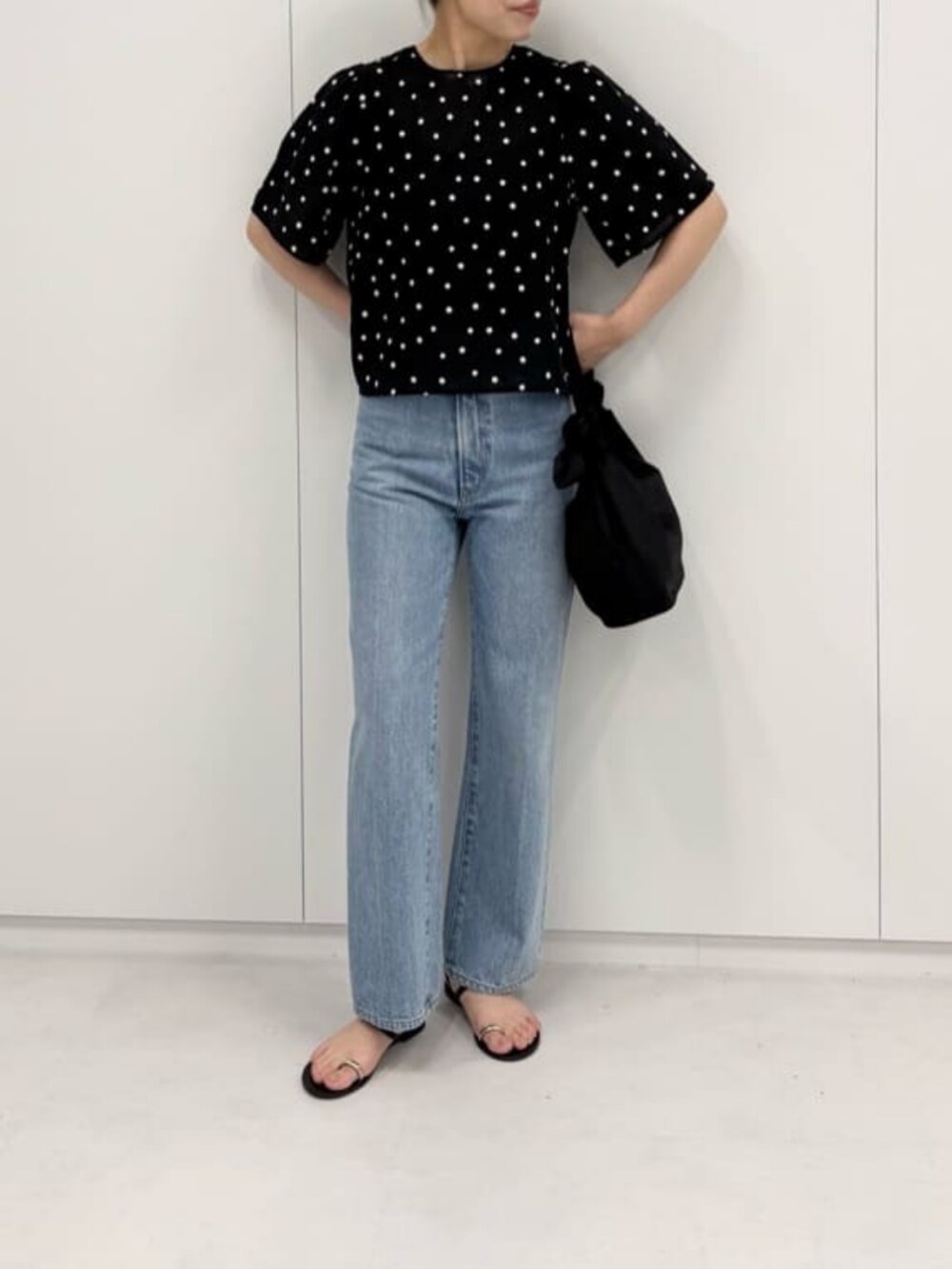 ブルー系のデニムパンツ、ブラック系のショルダーバッグ、ブラック系のシャツ/ブラウスを着用したレディースの夏コーディネートの3枚目の写真