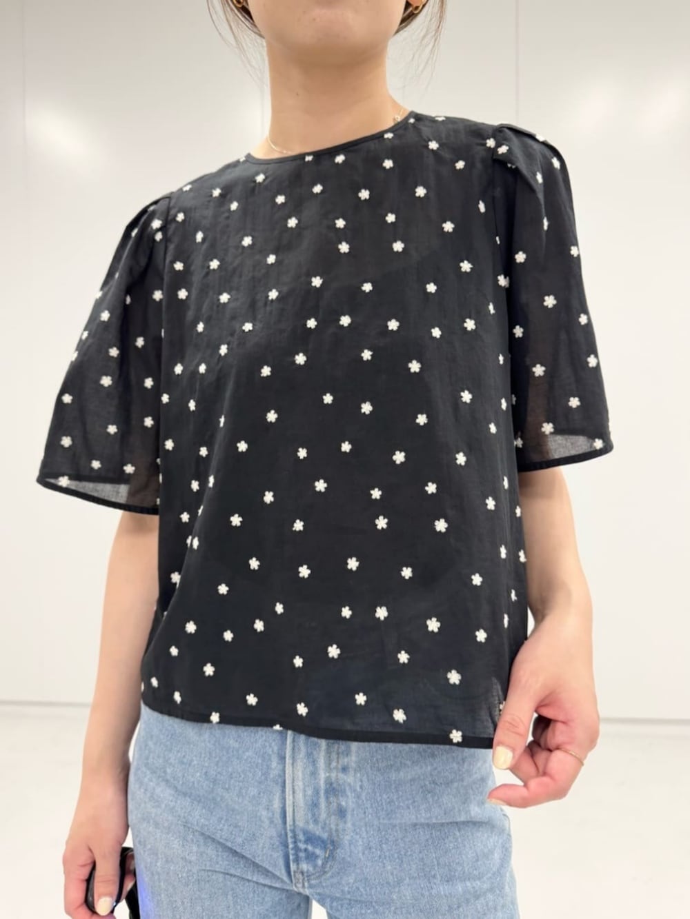 ブルー系のデニムパンツ、ブラック系のショルダーバッグ、ブラック系のシャツ/ブラウスを着用したレディースの夏コーディネートの2枚目の写真