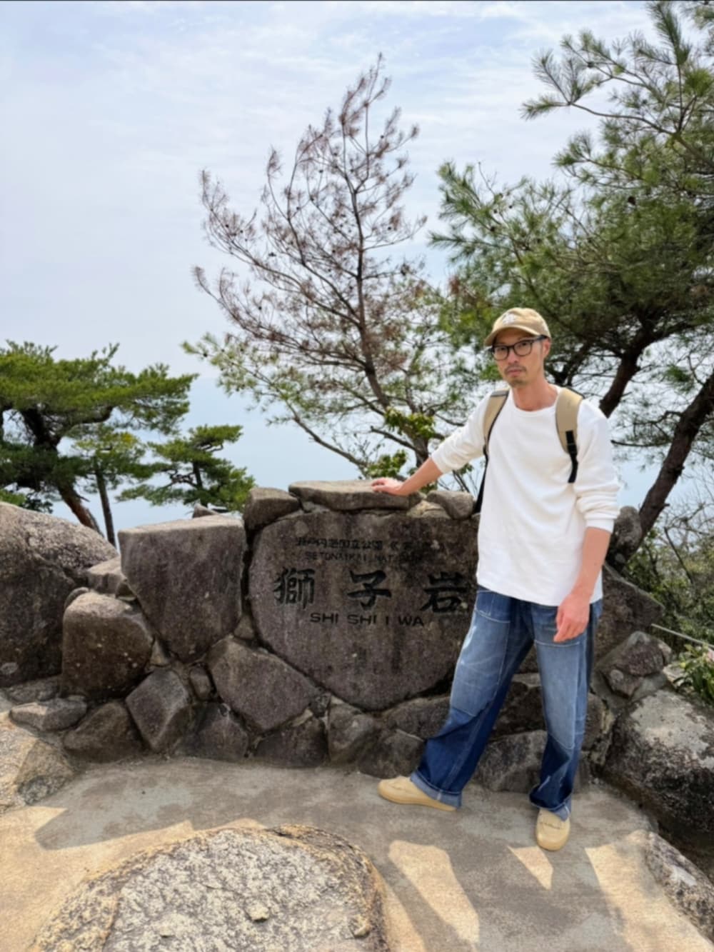 ピンク系のミリタリージャケット、ブルー系のデニムパンツ、ベージュ系のスニーカーを着用したメンズの春コーディネートの4枚目の写真