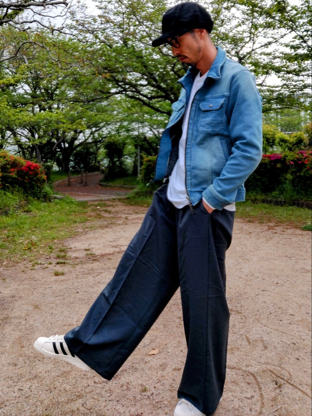 ブルー系のデニムジャケット、ブルー系のスラックス、ホワイト系のスニーカーを着用したメンズの春コーディネートの3枚目の写真
