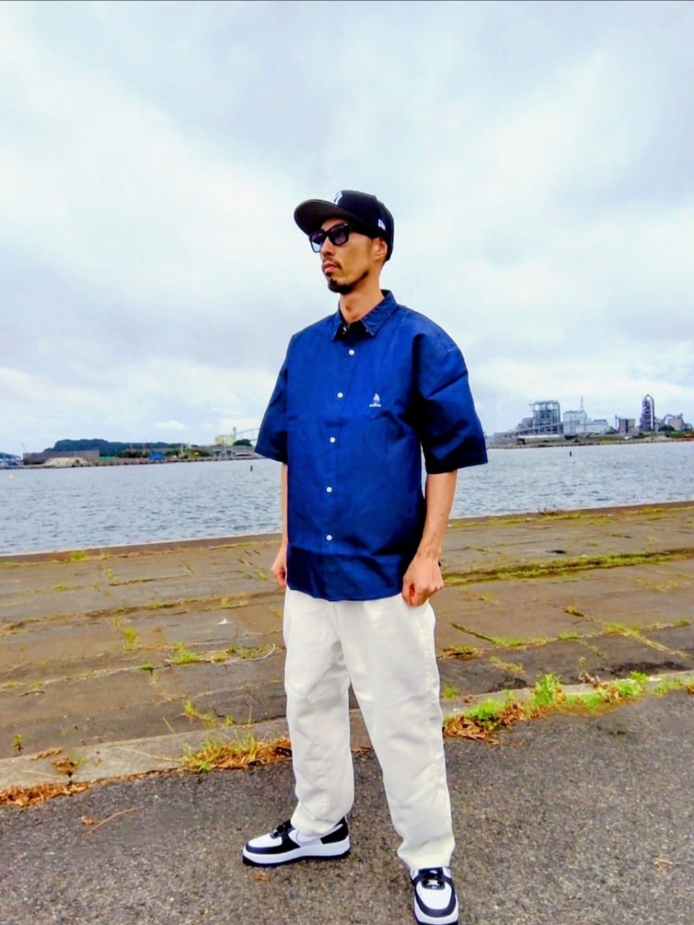 ブルー系のシャツ/ブラウス、ホワイト系のデニムパンツ、ブラック系のスニーカーを着用したメンズの夏コーディネートの2枚目の写真