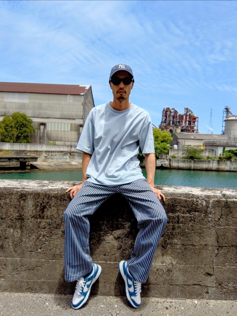 ブルー系のTシャツ/カットソー、ブルー系のデニムパンツ、ホワイト系のスニーカーを着用したメンズの春コーディネートの2枚目の写真