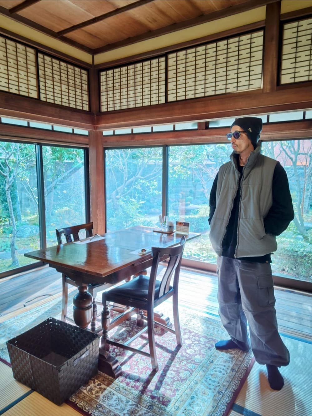 ブラック系のダウンベスト、ブラック系のスウェット、グレー系のカーゴパンツを着用したメンズの冬コーディネートの3枚目の写真