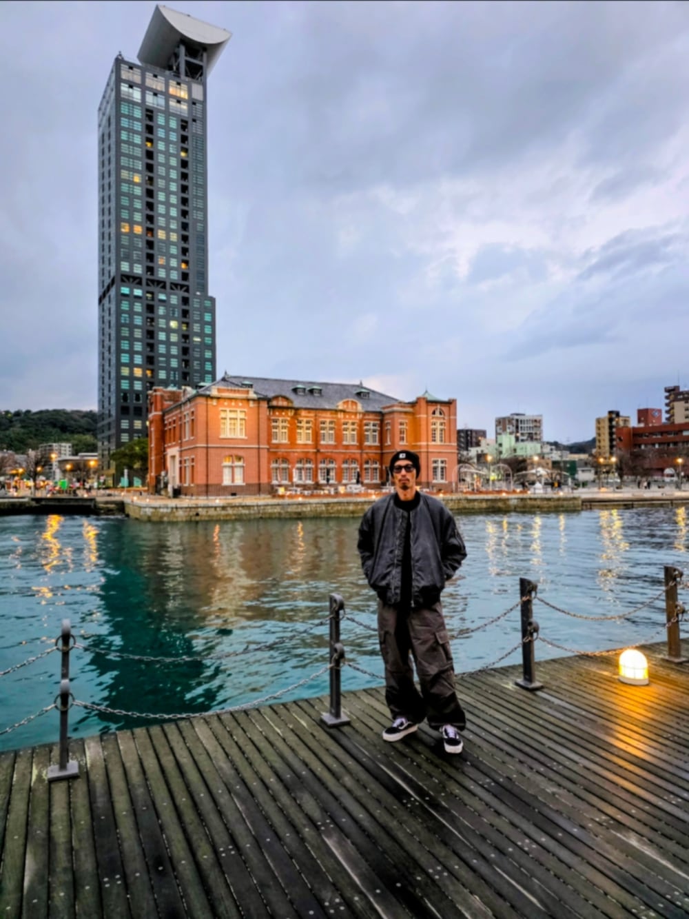 ブラック系のMA-1、グレー系のカーゴパンツ、ブラック系のスニーカーを着用したメンズの冬コーディネートの2枚目の写真