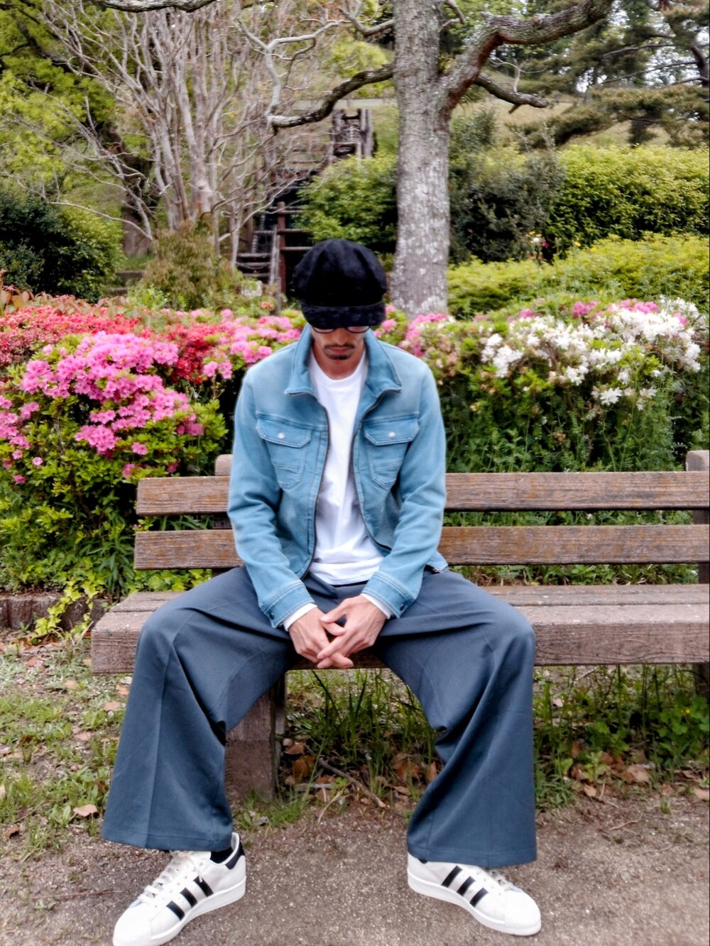 ブルー系のデニムジャケット、ブルー系のスラックス、ホワイト系のスニーカーを着用したメンズの春コーディネートの2枚目の写真