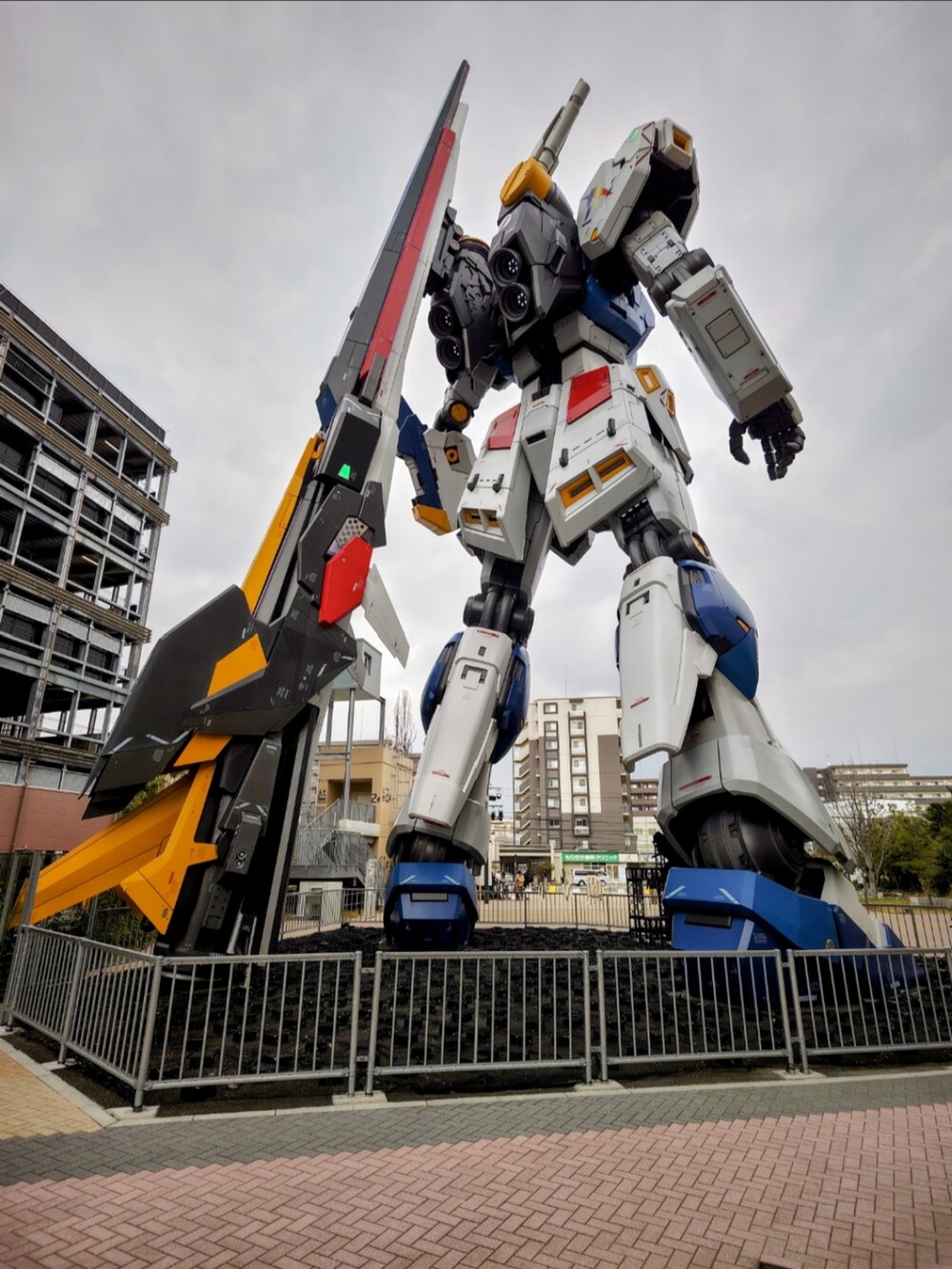 ブラック系のチェスターコート、ホワイト系のスニーカー、ブラック系のキャップを着用したメンズの冬コーディネートの3枚目の写真