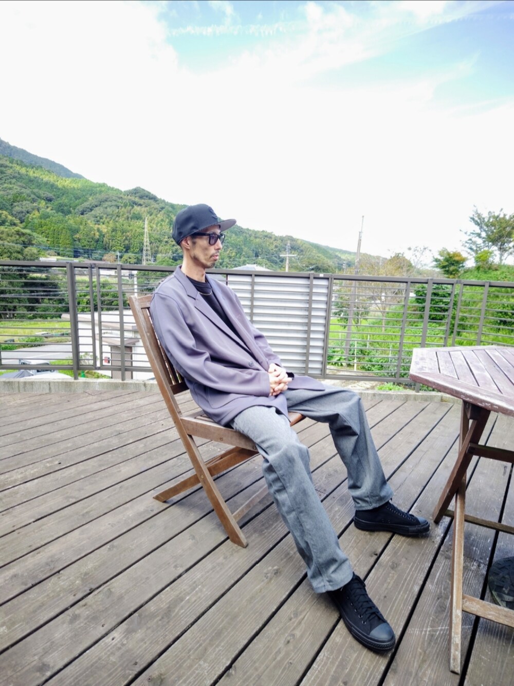 グレー系のテーラードジャケット、グレー系のその他パンツ、ブラック系のスニーカーを着用したメンズの秋コーディネートの2枚目の写真