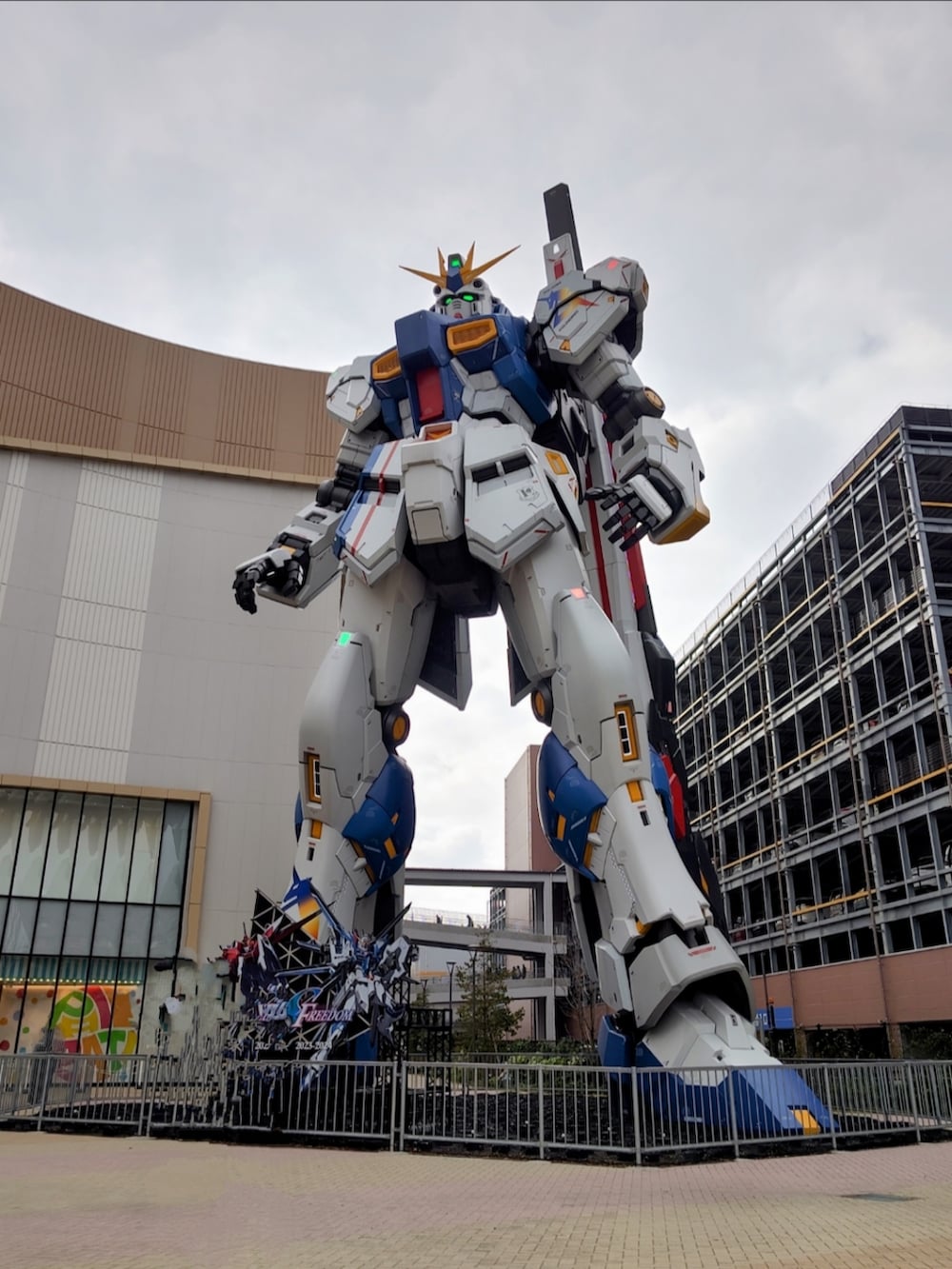 ブラック系のチェスターコート、ホワイト系のスニーカー、ブラック系のキャップを着用したメンズの冬コーディネートの2枚目の写真