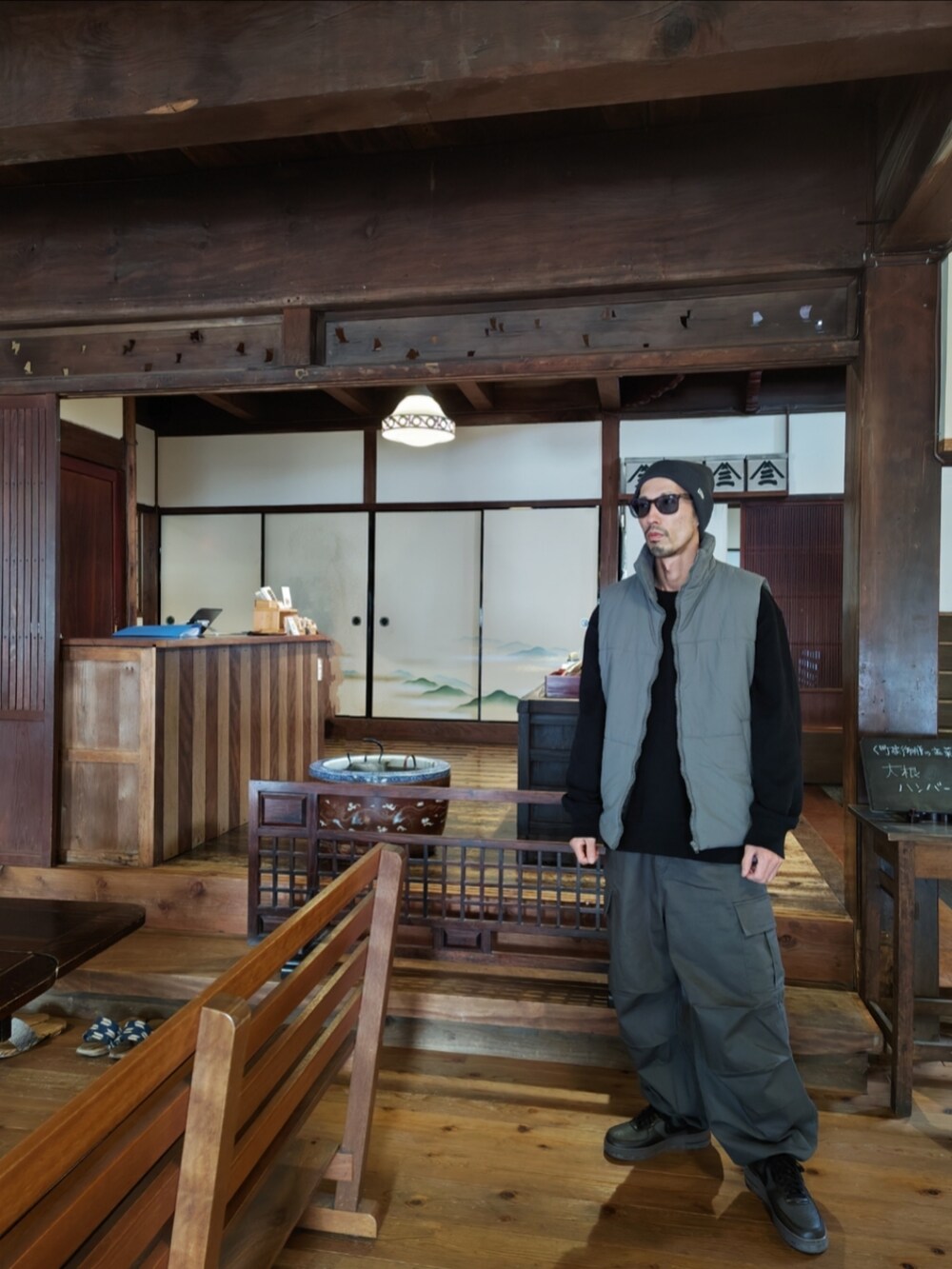 ブラック系のダウンベスト、ブラック系のスウェット、グレー系のカーゴパンツを着用したメンズの冬コーディネートの2枚目の写真