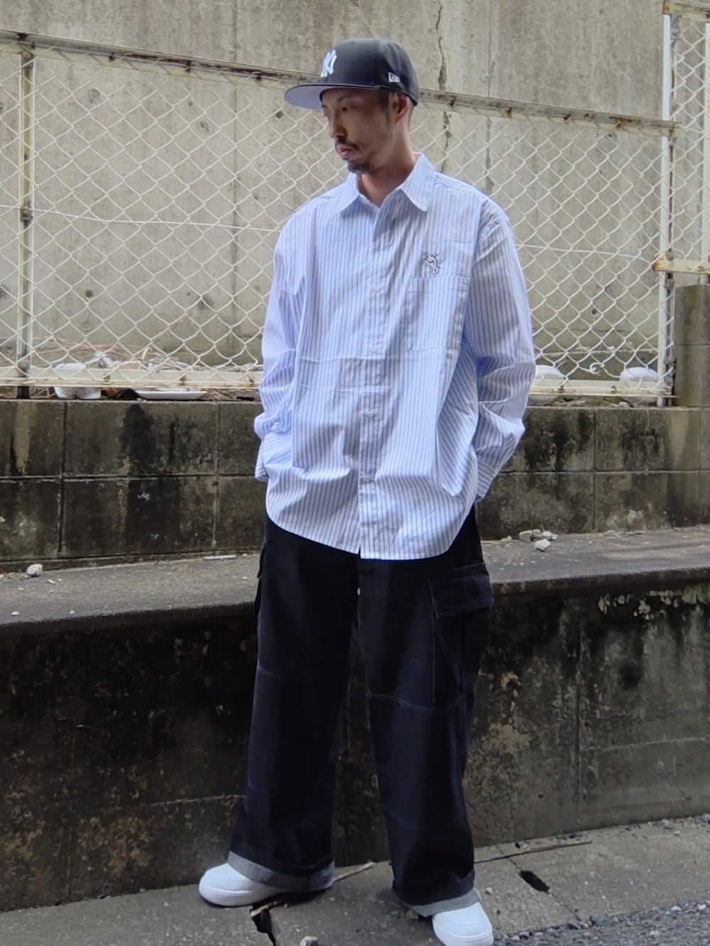 ホワイト系のシャツ/ブラウス、ブラック系のカーゴパンツ、ホワイト系のスニーカーを着用したメンズの夏コーディネートの2枚目の写真