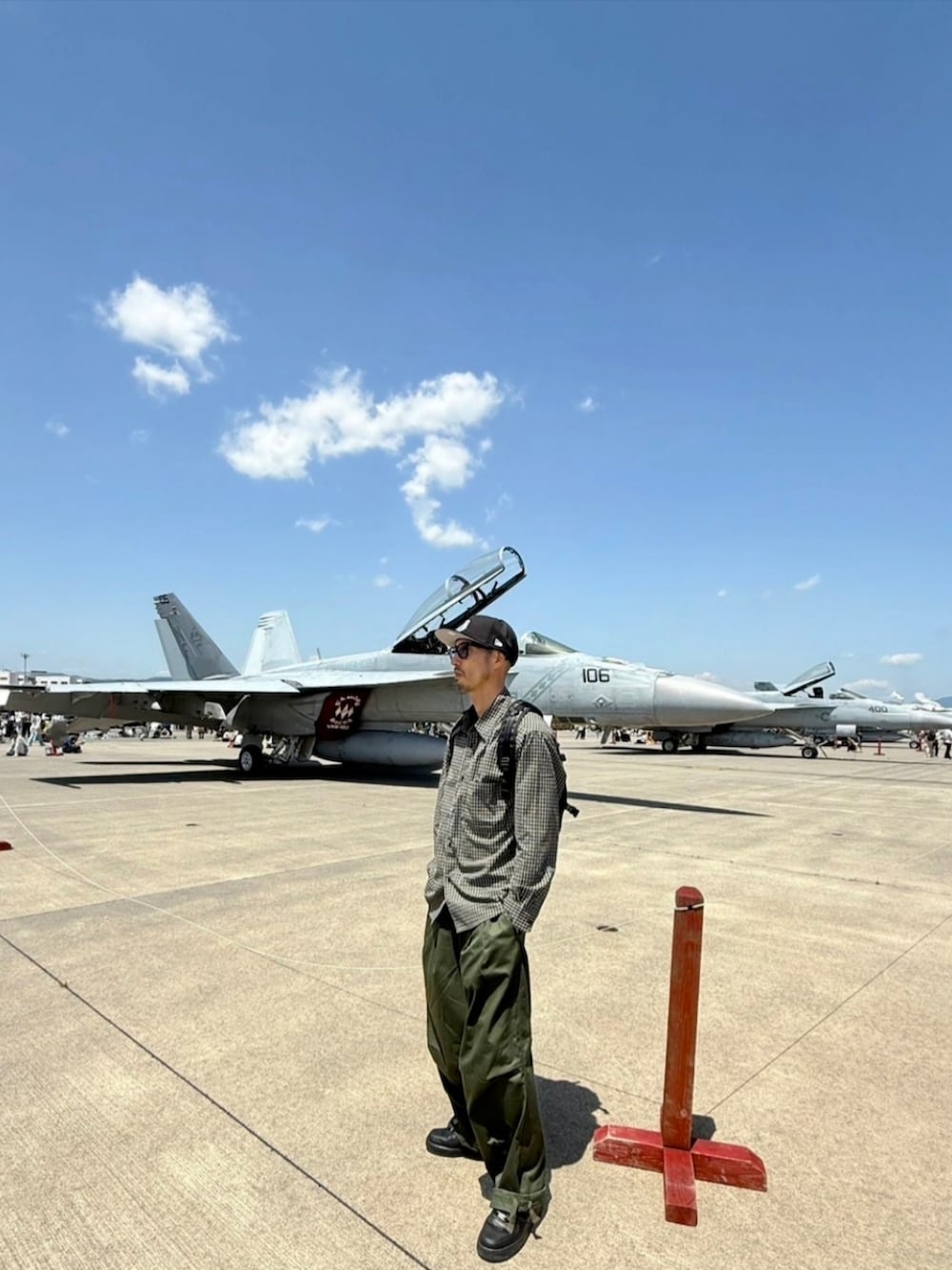 ブラック系のシャツ/ブラウス、ブラック系のバックパック/リュック、グリーン系のカーゴパンツを着用したメンズの春コーディネートの2枚目の写真