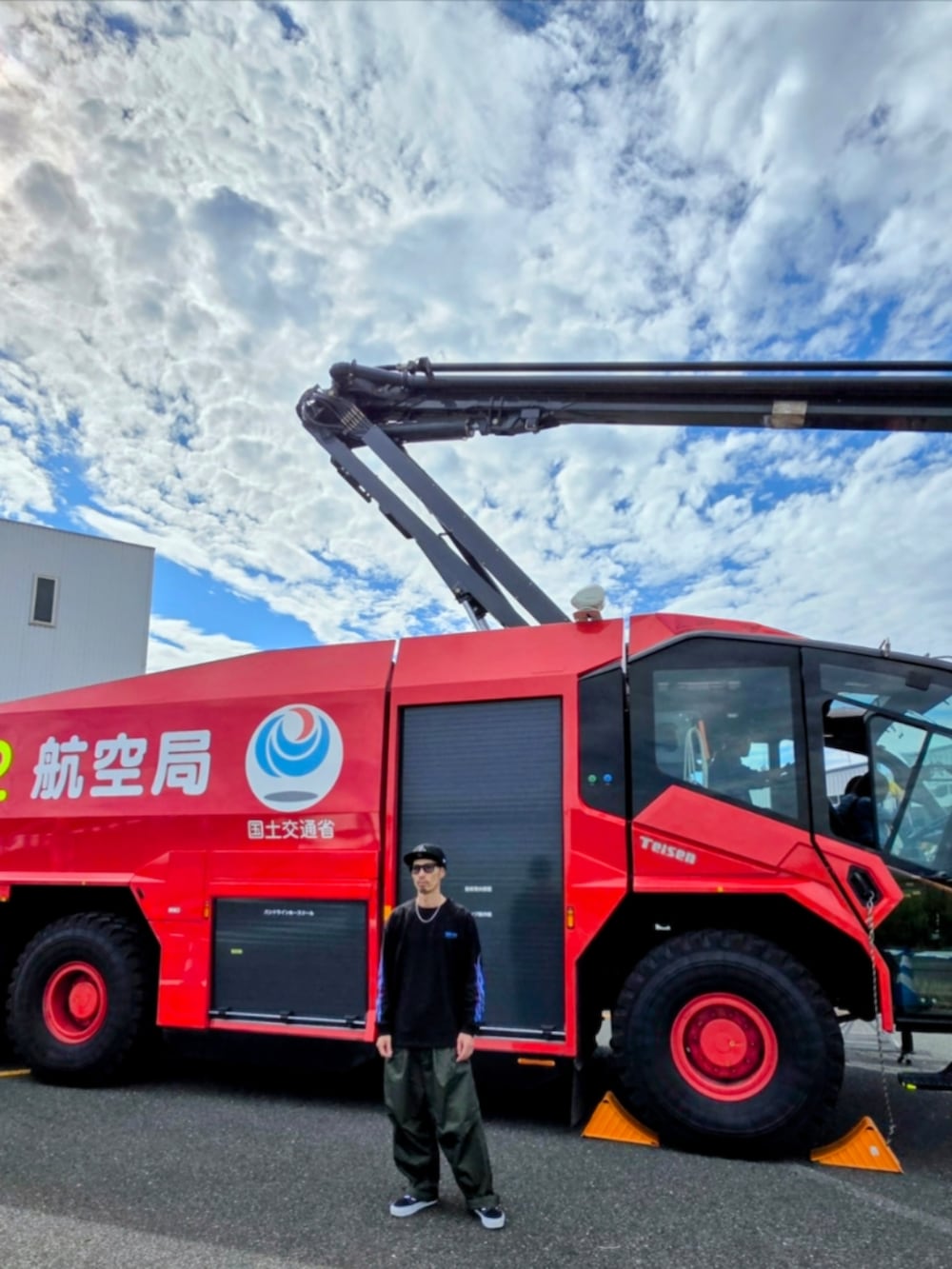 ブラック系のTシャツ/カットソー、グリーン系のカーゴパンツ、ブラック系のスニーカーを着用したメンズの秋コーディネートの5枚目の写真