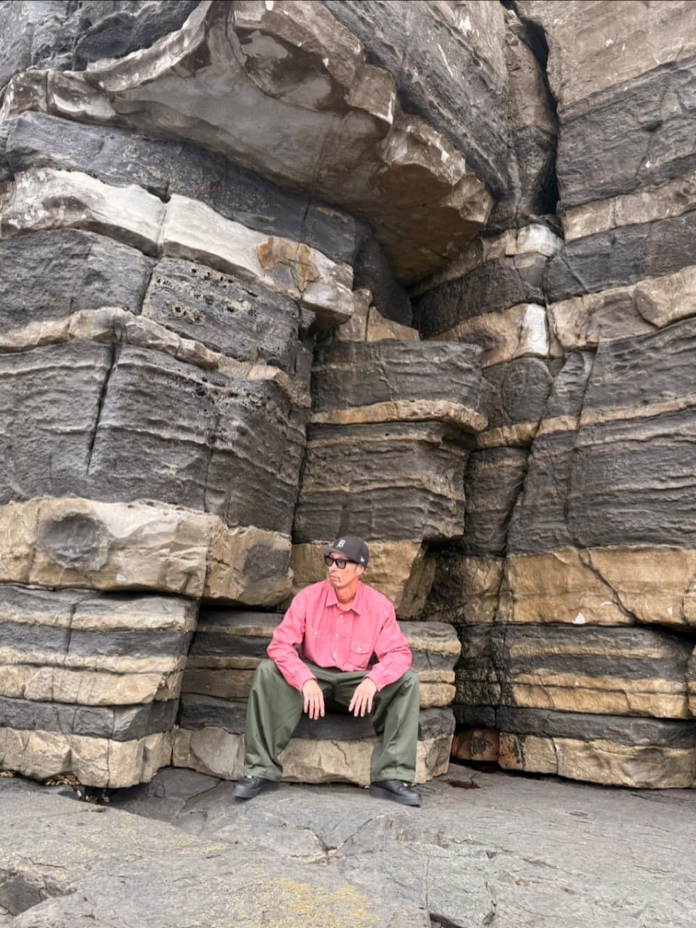 レッド系のシャツ/ブラウス、グリーン系のカーゴパンツ、ブラック系のスニーカーを着用したメンズの春コーディネートの2枚目の写真