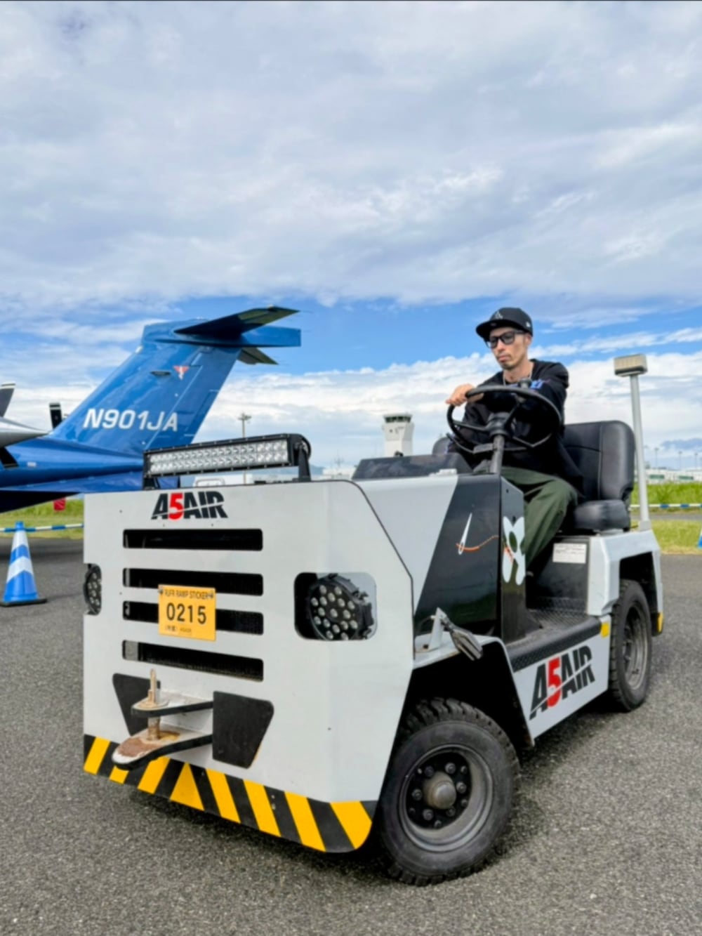 ブラック系のTシャツ/カットソー、グリーン系のカーゴパンツ、ブラック系のスニーカーを着用したメンズの秋コーディネートの4枚目の写真
