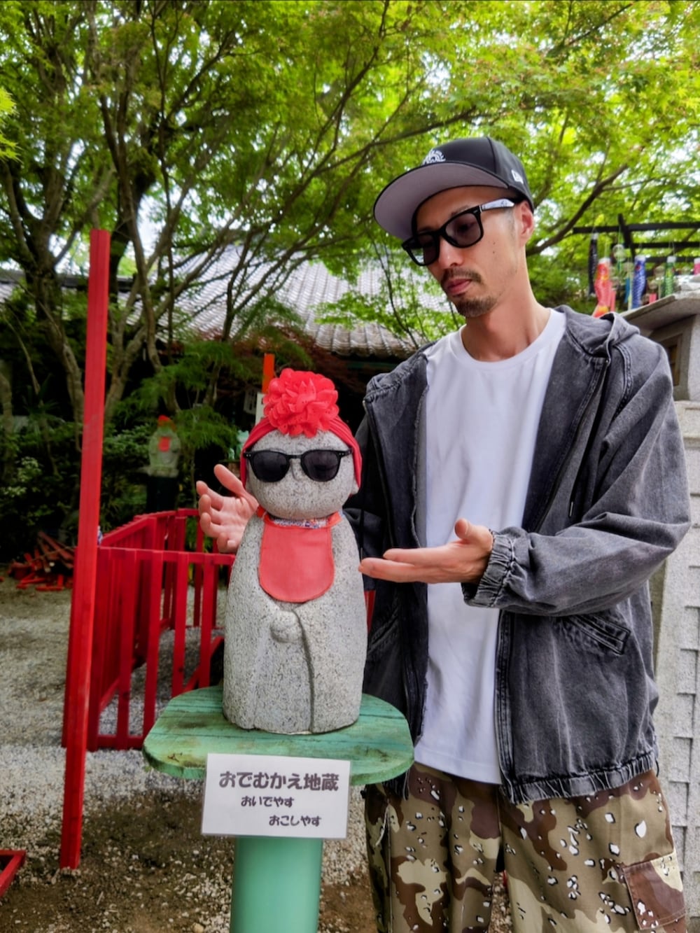 ブラック系のデニムジャケット、グリーン系のカーゴパンツ、ブラック系のスニーカーを着用したメンズの春コーディネートの4枚目の写真