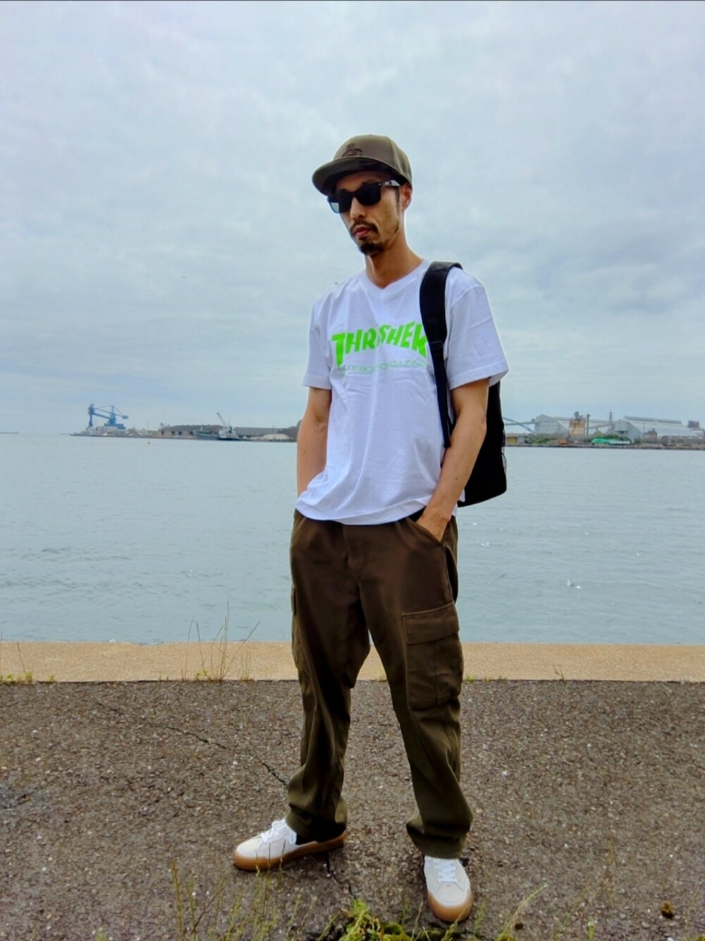 ホワイト系のTシャツ/カットソー、グリーン系のカーゴパンツ、ホワイト系のスニーカーを着用したメンズの春コーディネートの3枚目の写真