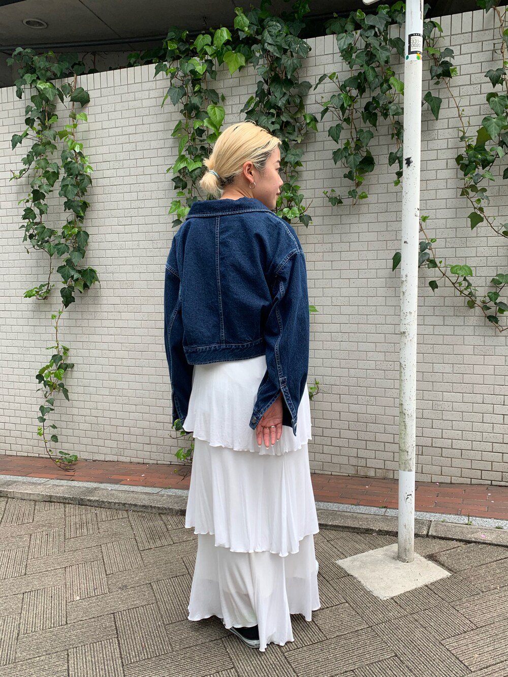 ブルー系のデニムジャケット、ホワイト系のスカートを着用したレディースの春コーディネートの2枚目の写真