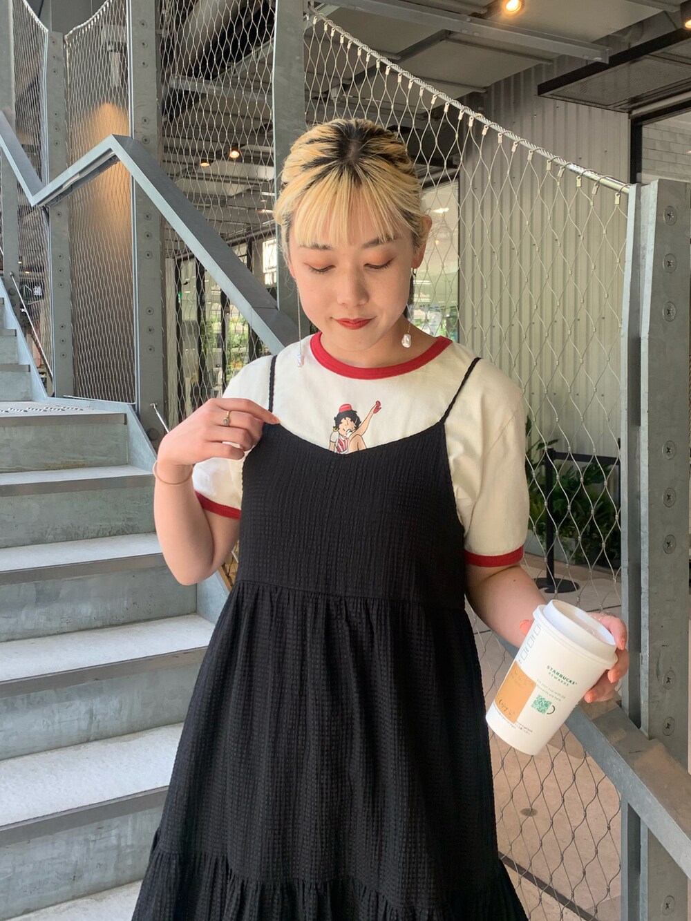 ブラック系のワンピース、ホワイト系のTシャツ/カットソーを着用したレディースの春コーディネートの3枚目の写真