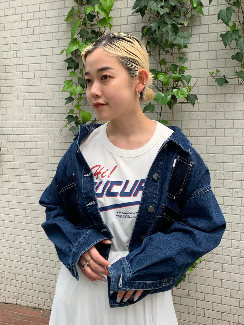 ブルー系のデニムジャケット、ホワイト系のスカートを着用したレディースの春コーディネートの3枚目の写真