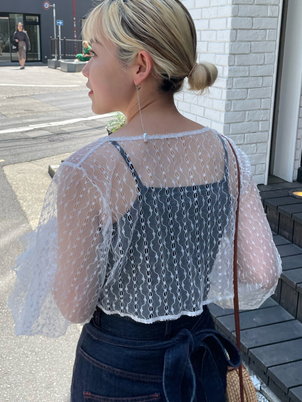 ブルー系のデニムパンツ、ホワイト系のシャツ/ブラウス、ブラック系のキャミソールを着用したレディースの春コーディネートの2枚目の写真