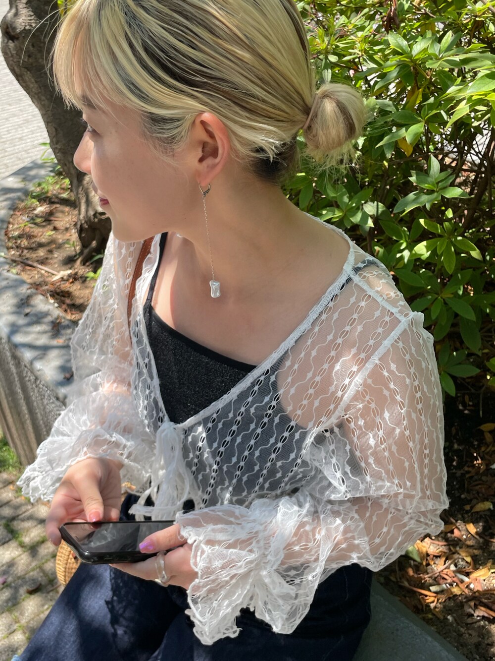 ブルー系のデニムパンツ、ホワイト系のシャツ/ブラウス、ブラック系のキャミソールを着用したレディースの春コーディネートの3枚目の写真