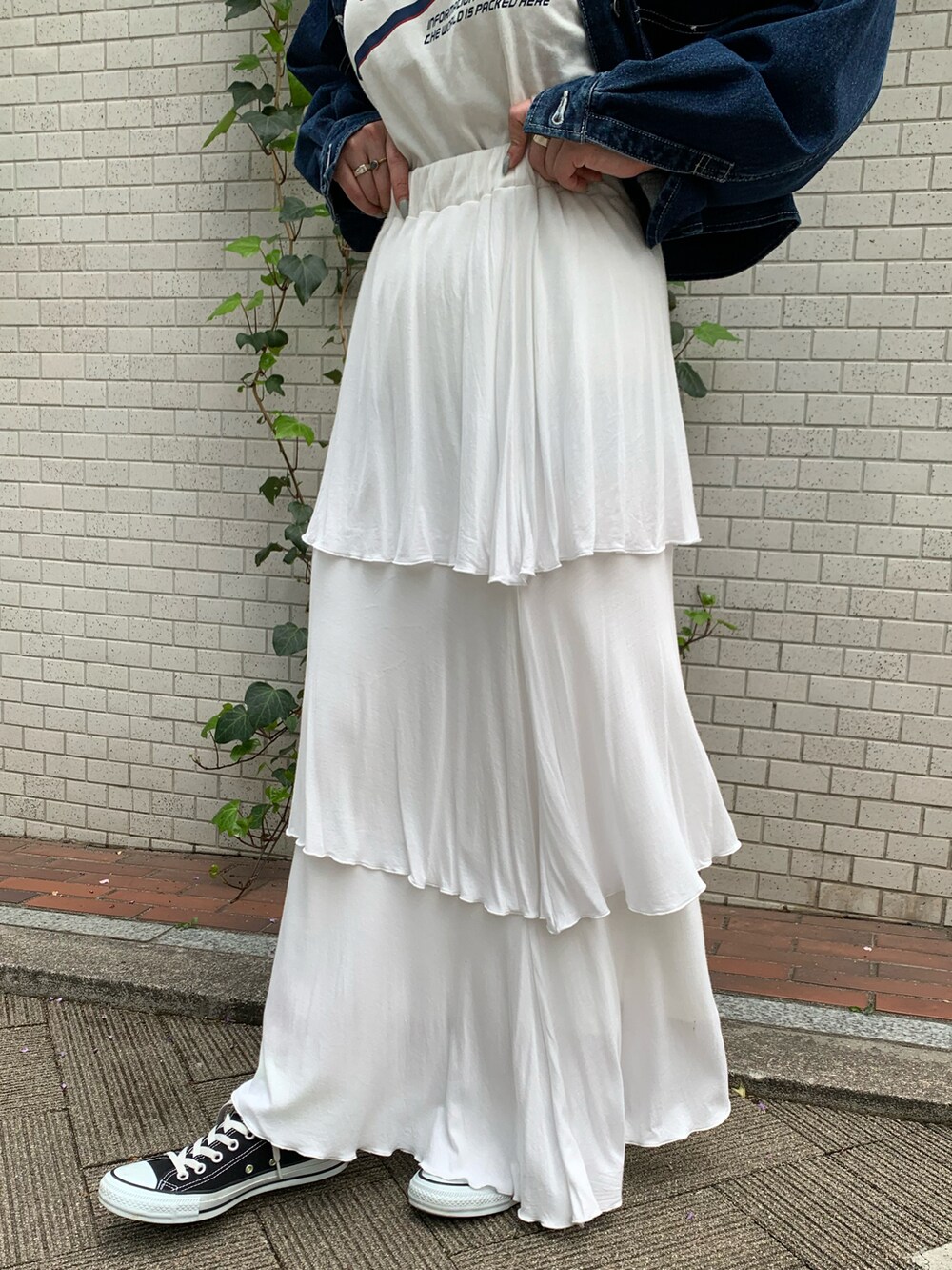 ブルー系のデニムジャケット、ホワイト系のスカートを着用したレディースの春コーディネートの4枚目の写真