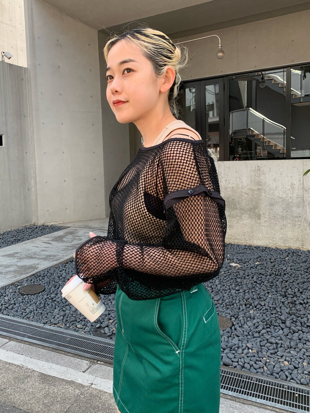 ブラック系のTシャツ/カットソー、グリーン系のスカートを着用したレディースの春コーディネートの4枚目の写真