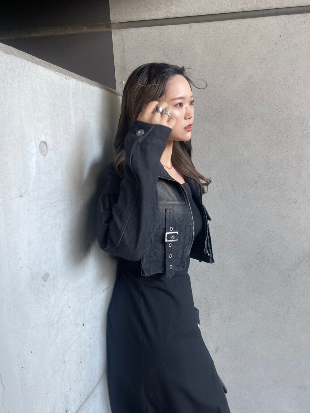 ブラック系のデニムジャケット、ブラック系のワンピース/ドレス、ブラック系のブーツを着用したレディースの春コーディネートの2枚目の写真