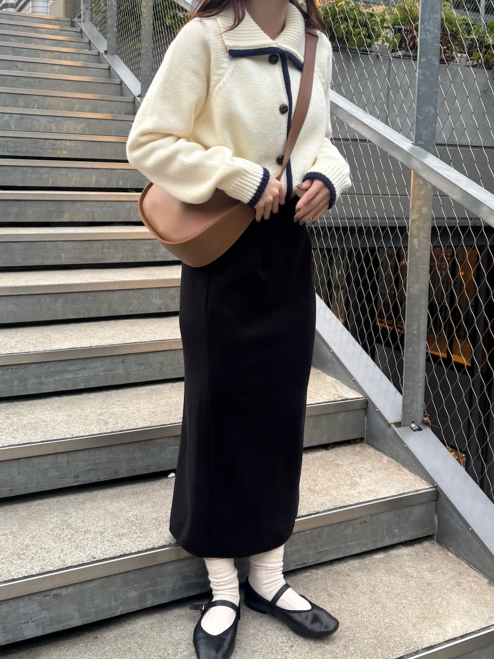 ブラック系のスカート、ブラック系のパンプスを着用したレディースの秋コーディネートの4枚目の写真