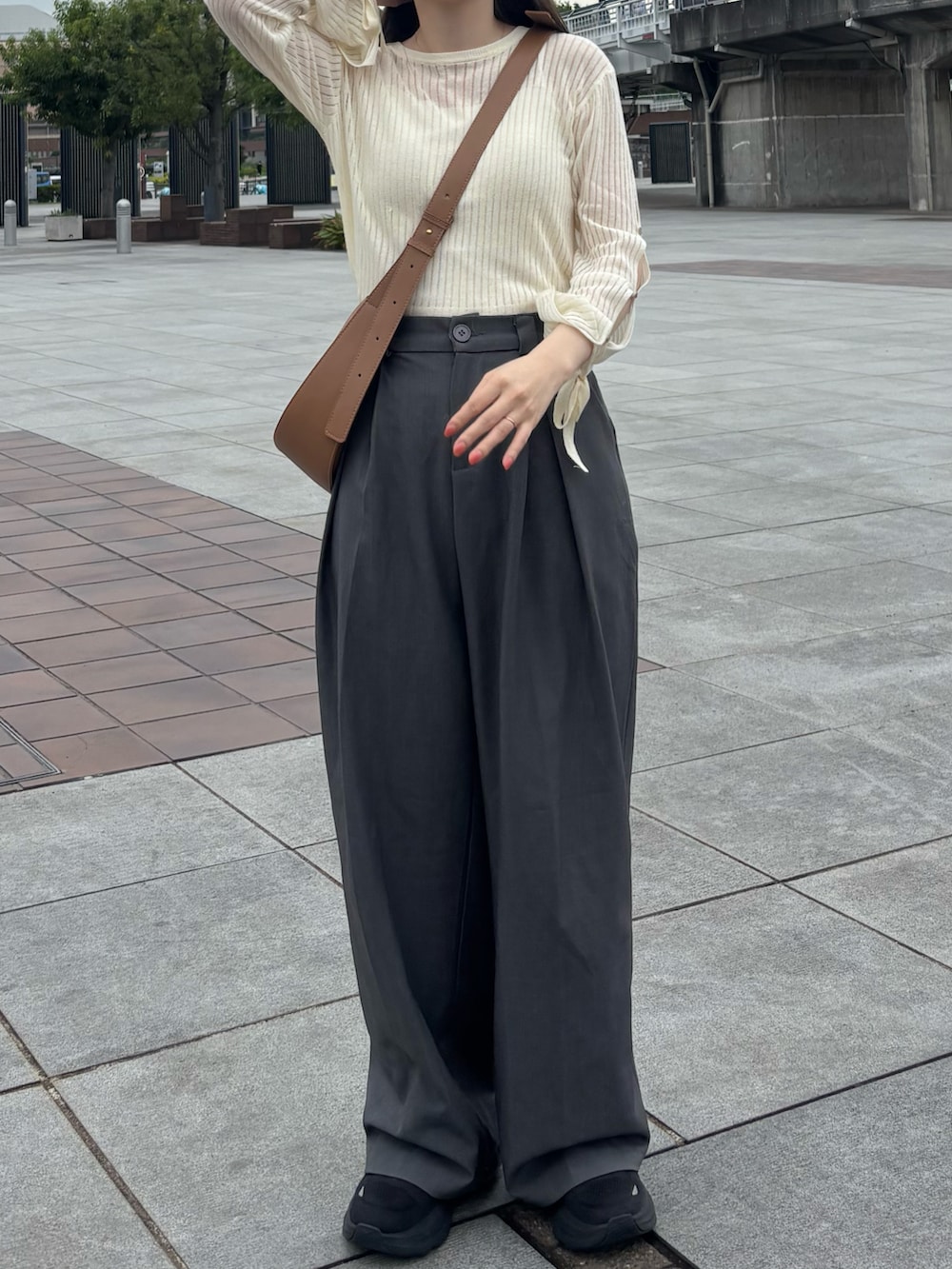 グレー系のスラックス、ホワイト系のニット/セーターを着用したレディースの秋コーディネートの2枚目の写真