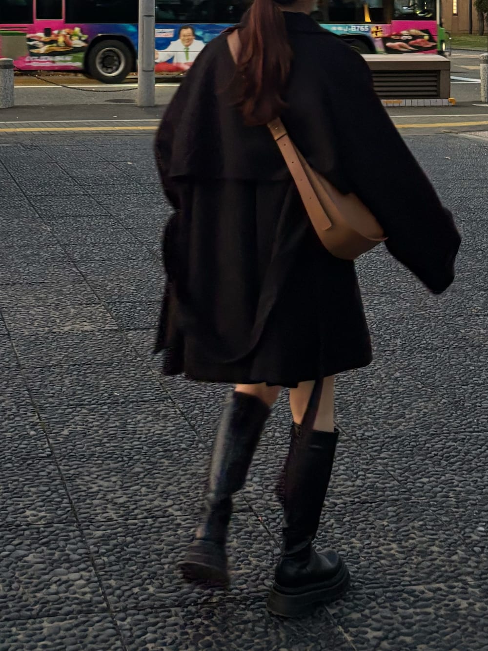 ブラック系のブーツ、ブラック系のトレンチコートを着用したレディースの秋コーディネートの3枚目の写真