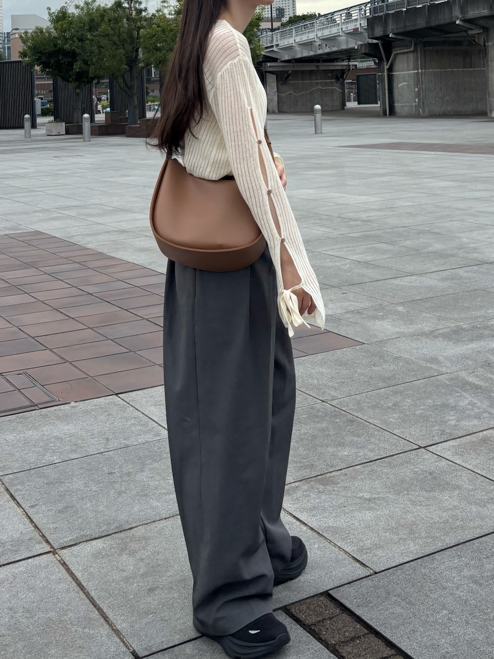 グレー系のスラックス、ホワイト系のニット/セーターを着用したレディースの秋コーディネートの3枚目の写真