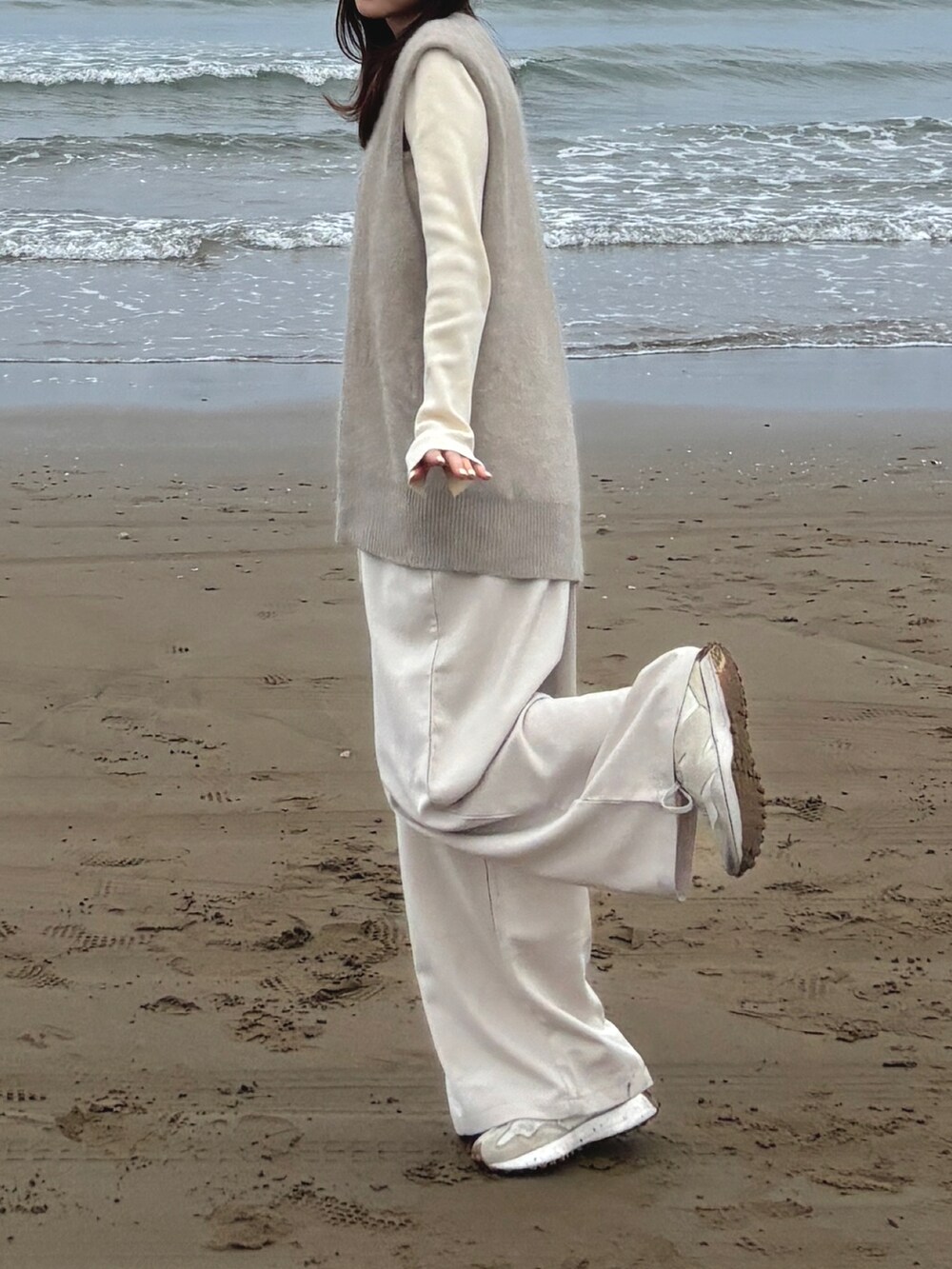 ベージュ系のベスト、ホワイト系のカーディガン/ボレロ、ホワイト系のサロペット/オーバーオールを着用したレディースの秋コーディネートの2枚目の写真