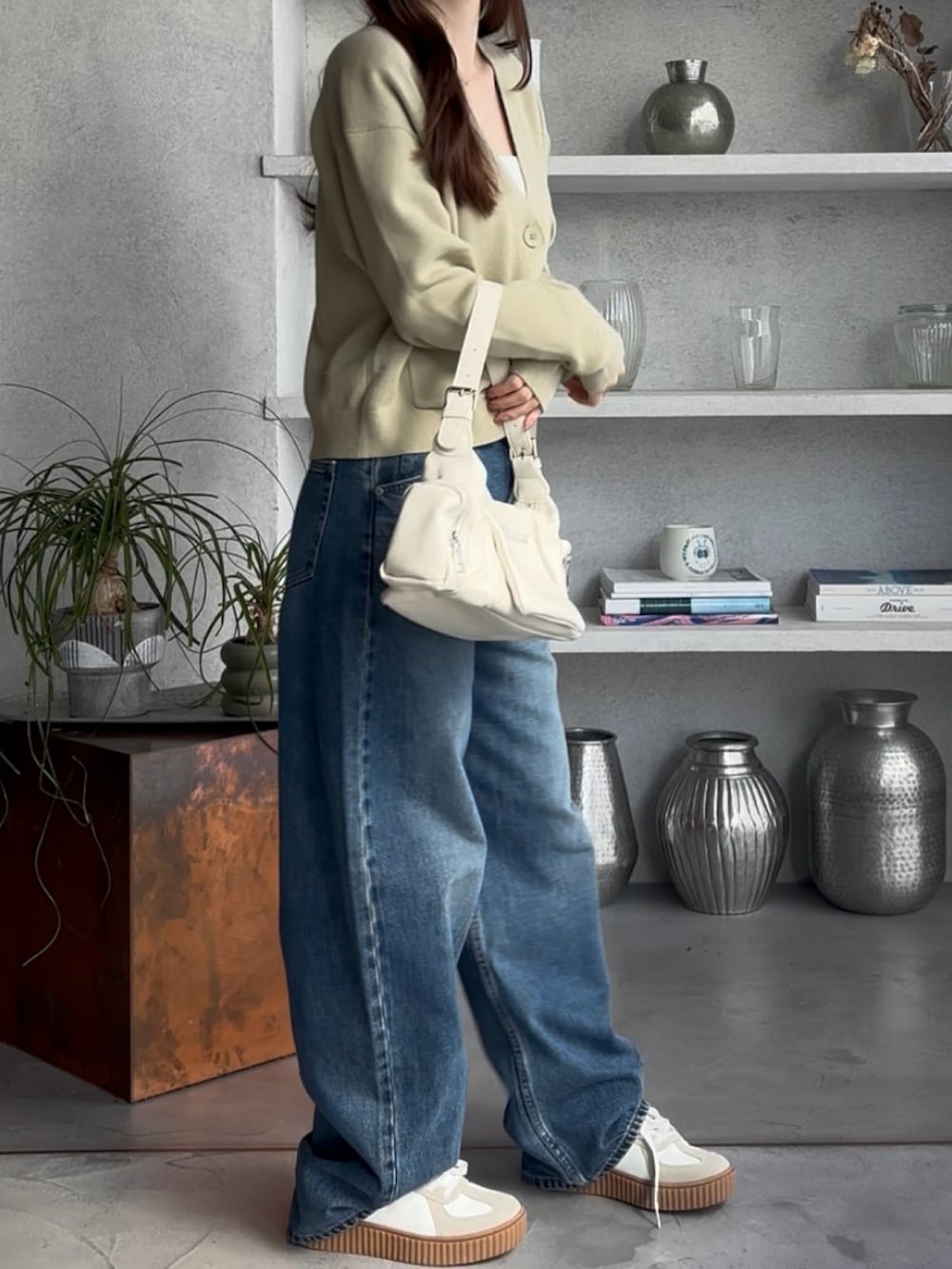 グリーン系のカーディガン/ボレロ、ブルー系のデニムパンツを着用したレディースの冬コーディネートの2枚目の写真