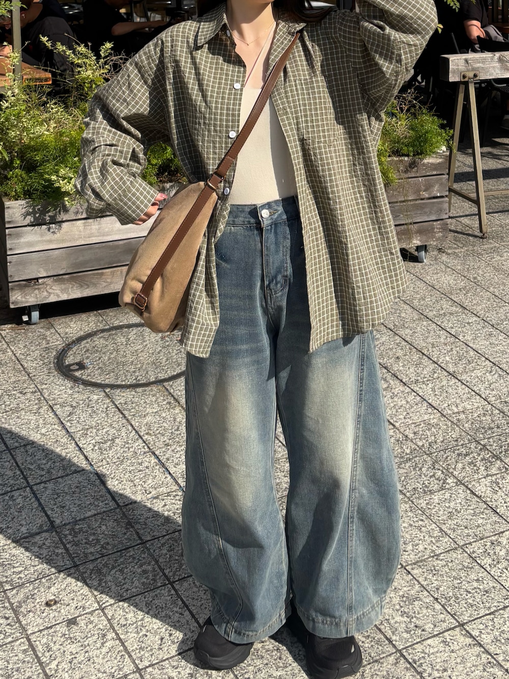ブルー系のデニムパンツ、ブラック系のスニーカーを着用したレディースの春コーディネートの2枚目の写真