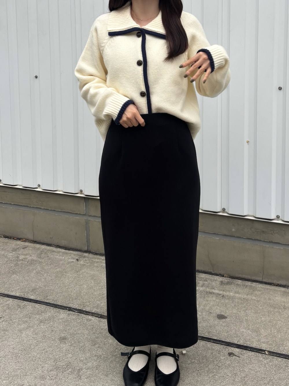 ブラック系のスカート、ブラック系のパンプスを着用したレディースの秋コーディネートの2枚目の写真