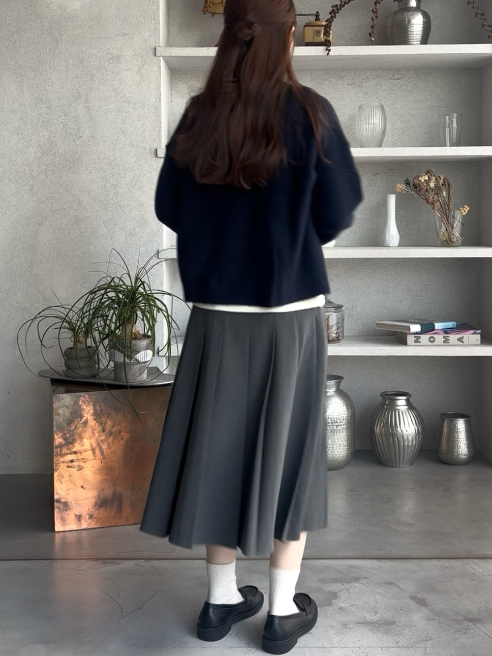 ブルー系のカーディガン/ボレロ、グレー系のスカートを着用したレディースの冬コーディネートの2枚目の写真