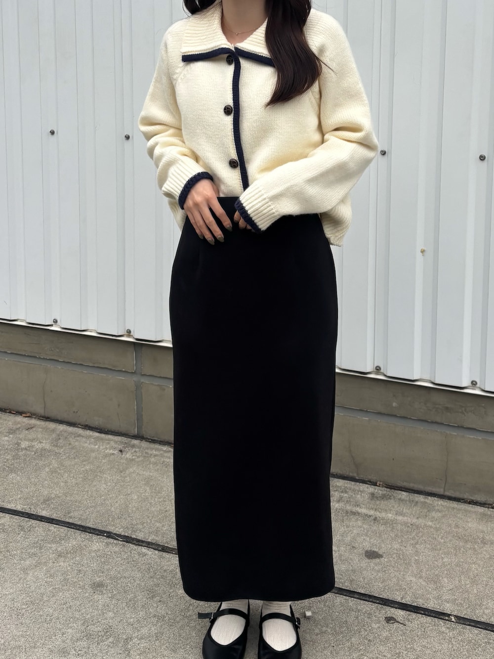ブラック系のスカート、ブラック系のパンプスを着用したレディースの秋コーディネートの3枚目の写真